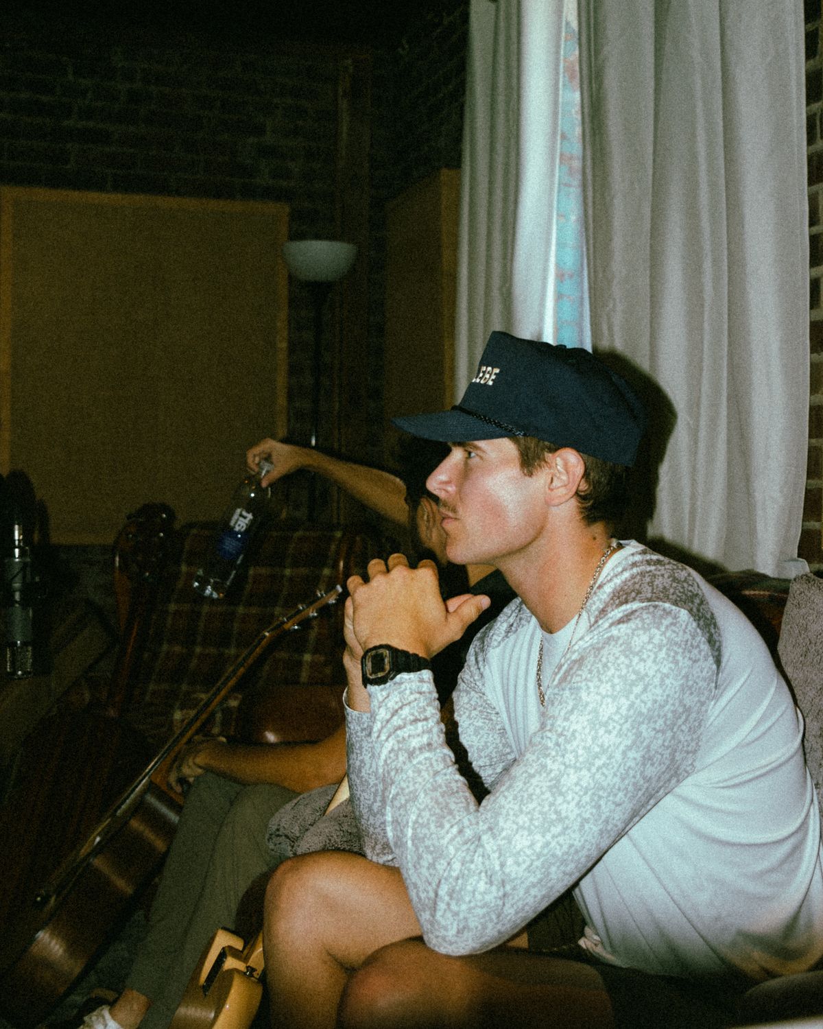 Jonah listening closely during a studio session, guitars beside him